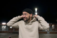 Load image into Gallery viewer, Stefan Kuhnigk wearing the thecoffeemonsters "19 "Angry Chicken" crema standard hoodie" at night in a carpark, lifting the hood, smiling..