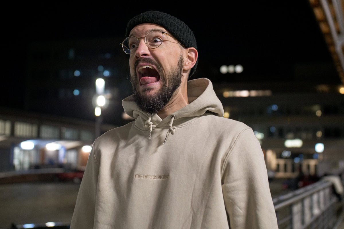 Stefan Kuhnigk wearing the thecoffeemonsters "19 "Angry Chicken" crema standard hoodie" at night in a carpark, screaming for fun.